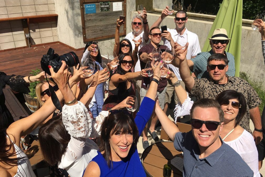 Group of happy people toasting and raising their wine glasses