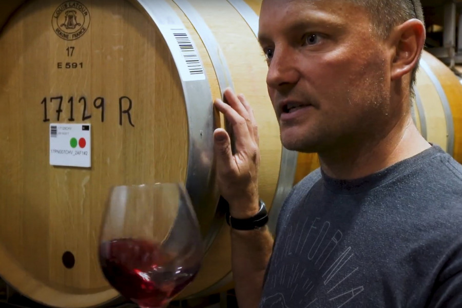 barrel tasing in the wine cellar with winemaker holding glass of red wine