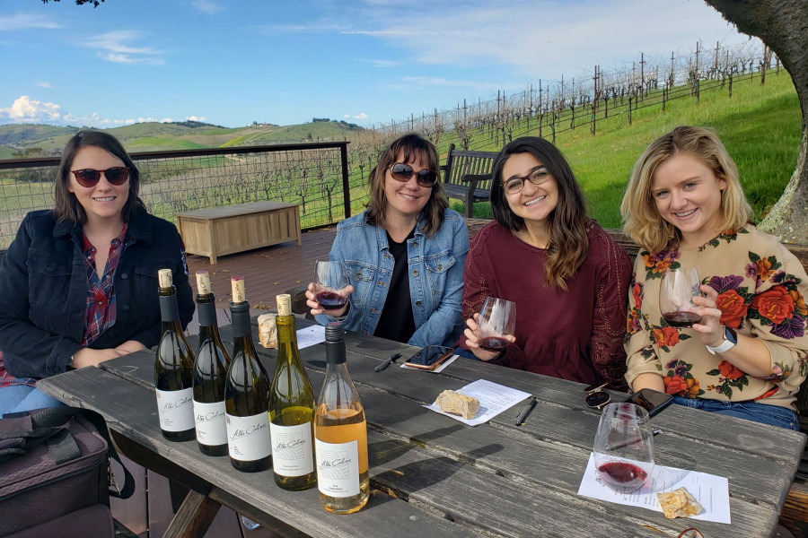 Small group of ladies enjoying VIP hilltop wine tasting with Maggie Tillman of Alta Colina, Paso Robles, green vineyards and bright blue sky
