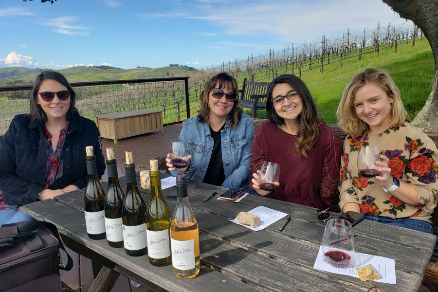 Small group of ladies enjoying VIP hilltop wine tasting with Maggie Tillman of Alta Colina, Paso Robles, green vineyards and bright blue sky